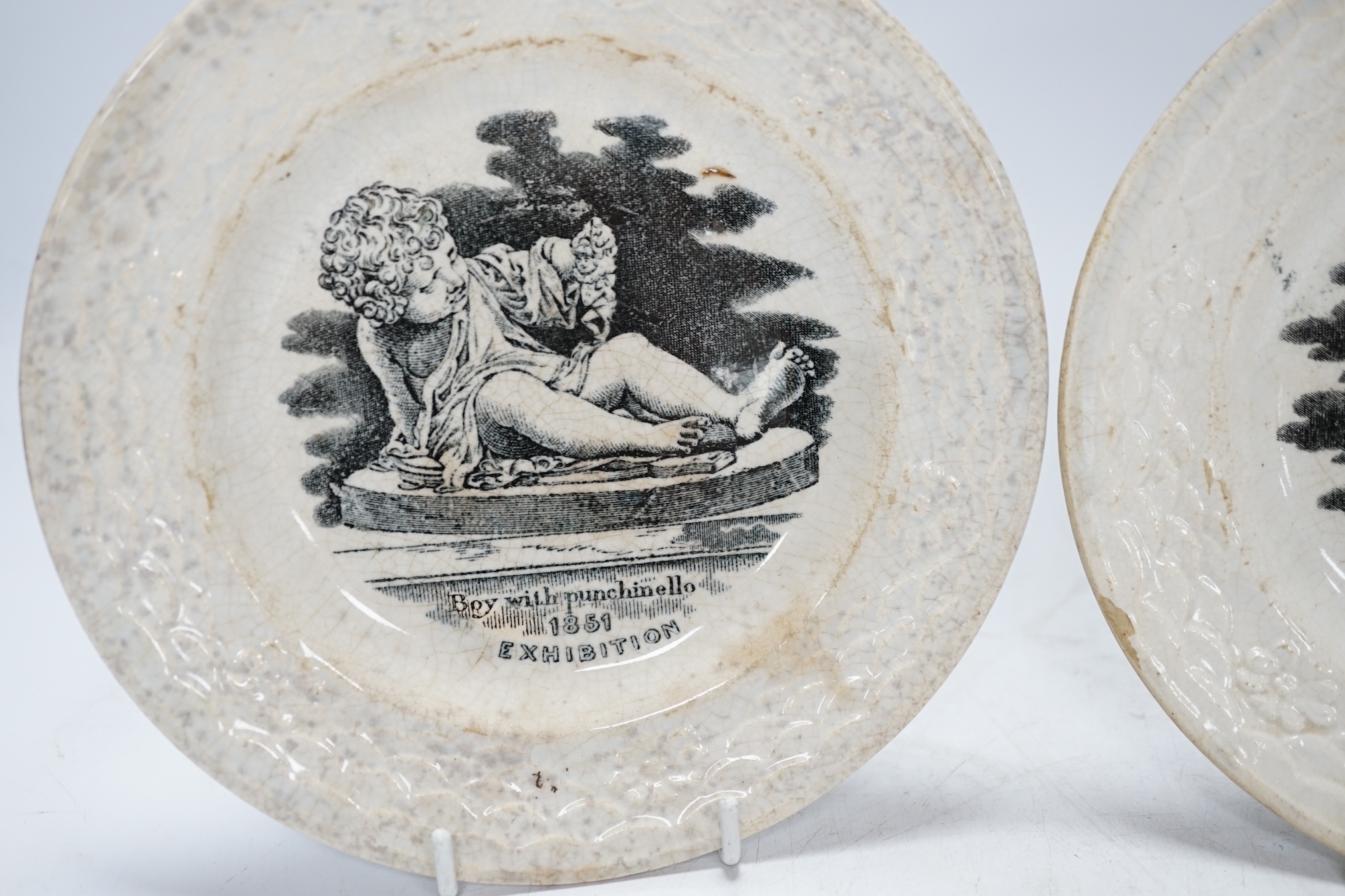 From the Studio of Fred Cuming. A pair of printed 1851 exhibition plates ‘Boy with Punchinello’ and ‘Massacre of the Innocent’, 17cm in diameter. Condition - poor to fair